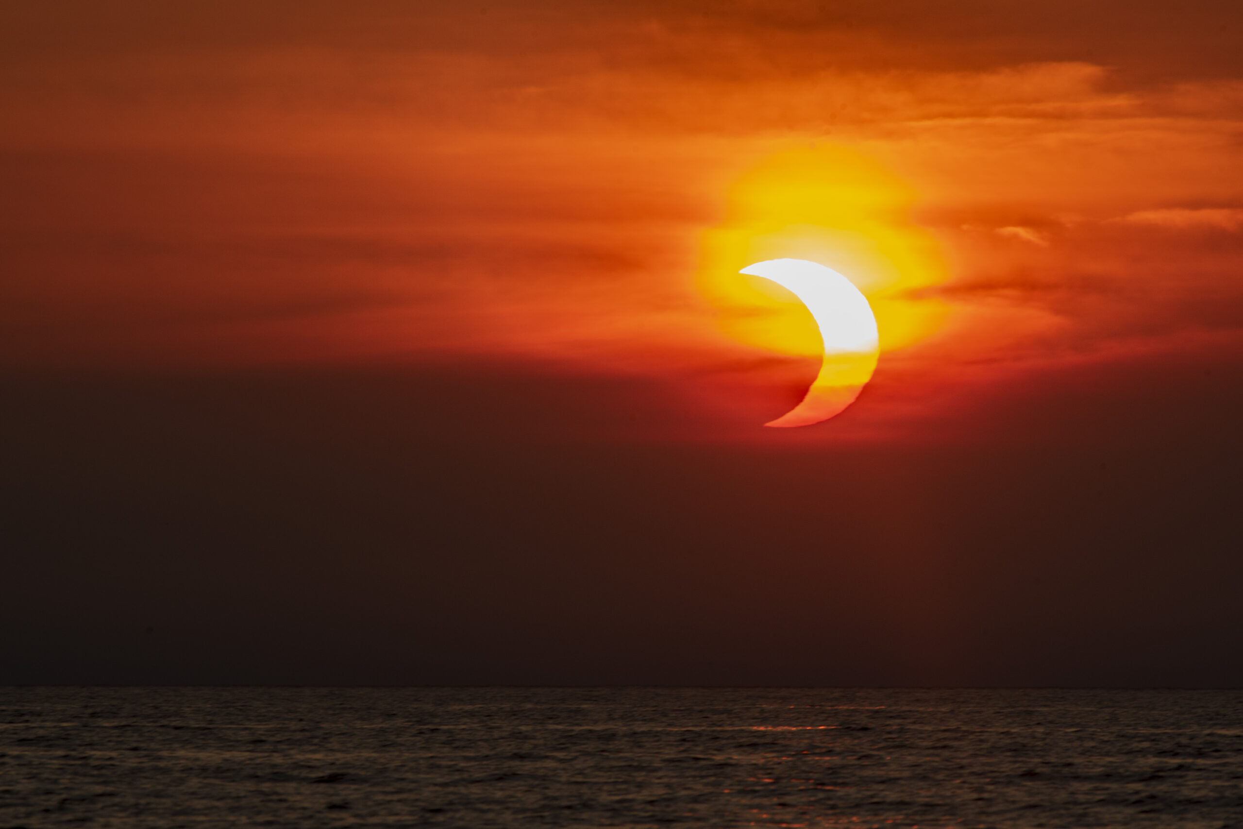 Partially eclipsed sunrise over Lake Huron